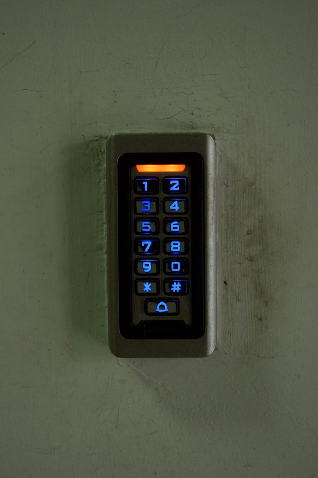 Backlit access control keypad next to a door